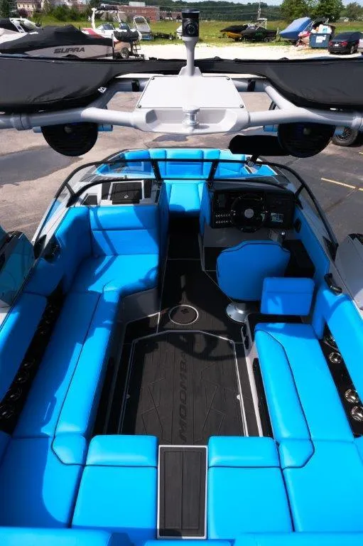 Slide: The Image of 2025 Moomba Max boat interior with vibrant blue seating and modern dashboard. - 11