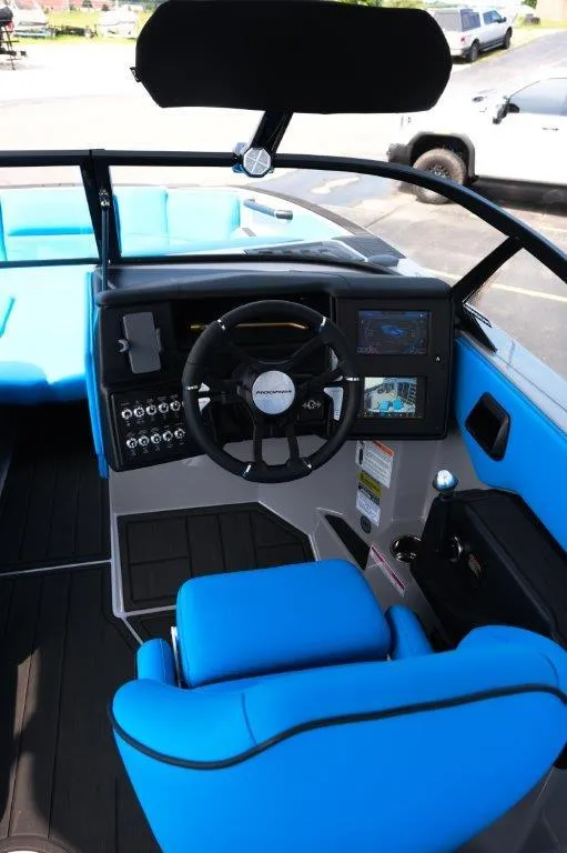 Slide: The Image of 2025 Moomba Max boat interior with blue seating and modern dashboard controls. - 13
