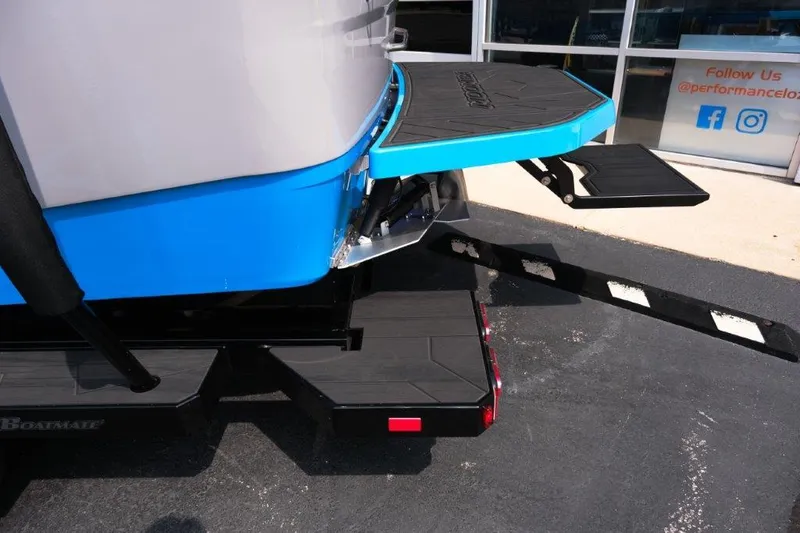 Slide: The Image of 2025 Moomba Max boat rear view with blue detailing and swim platform. - 8