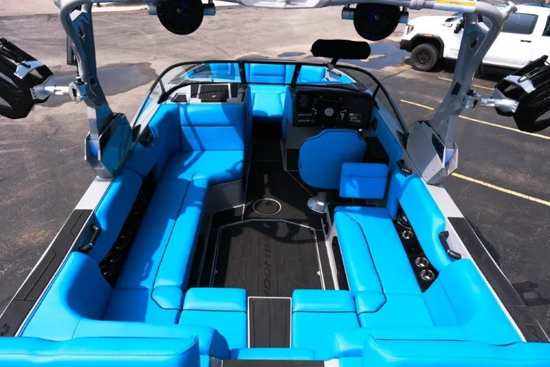 Slide: The Image of 2025 Moomba Max boat interior with vibrant blue seating and modern dashboard. - 9