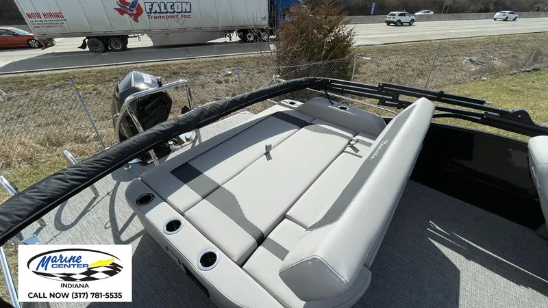 Slide: The Image of 2025 Barletta Aria A24UC boat interior with seating, parked near highway. - 16