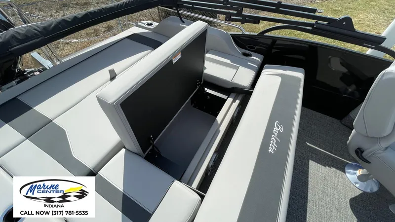 Slide: The Image of 2025 Barletta Aria A24UC boat interior with seating and storage, Marine Center contact info. - 18