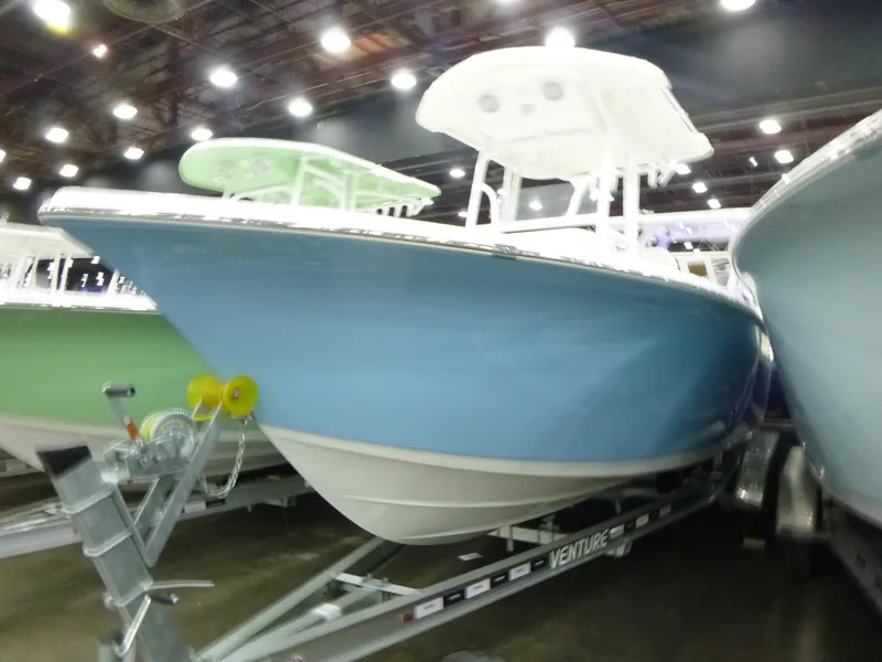 Slide: The Image of 2025 Sea Pro 225FLX Sandbar boat on trailer, light blue hull, outdoor display. - 2