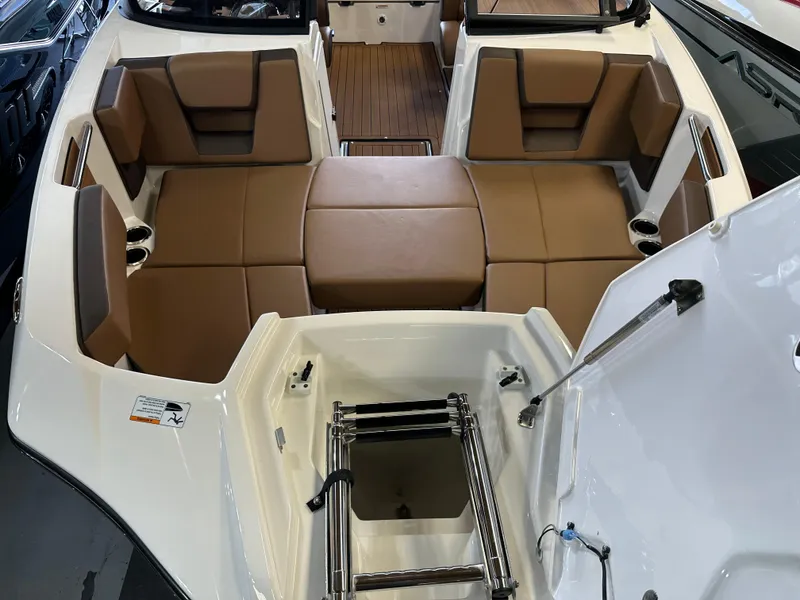 Slide: The Image of 2024 Yamaha 222SD jet boat interior with brown seating and integrated ladder. - 15