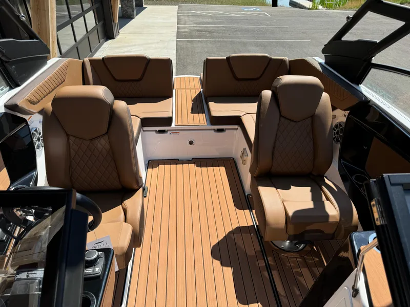 Slide: The Image of 2024 Yamaha 222SD jet boat interior with tan leather seating and wood-style flooring. - 7