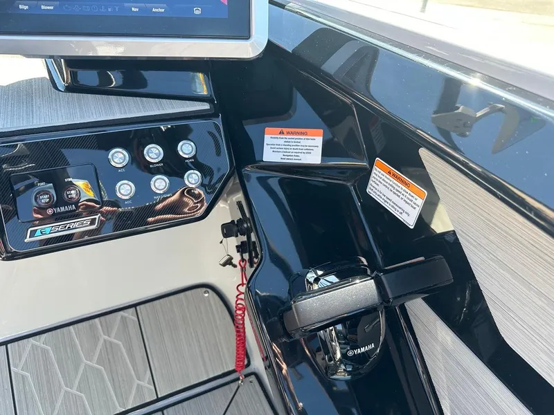 Slide: The Image of 2024 Yamaha 222XD jet boat dashboard with control panel and warning labels. - 14