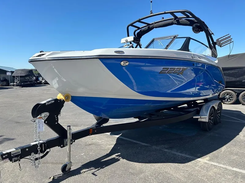 Slide: The Image of 2024 Yamaha 222XD jet boat in blue on a trailer, parked outdoors. - 5