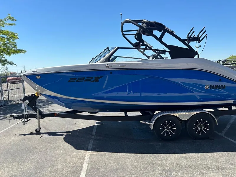 Slide: The Image of 2024 Yamaha 222XD jet boat in blue on a trailer, parked outdoors. - 6