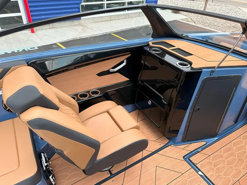 Slide: The Image of 2024 Yamaha 222XD jet boat interior with tan seats and sleek dashboard design. - 13