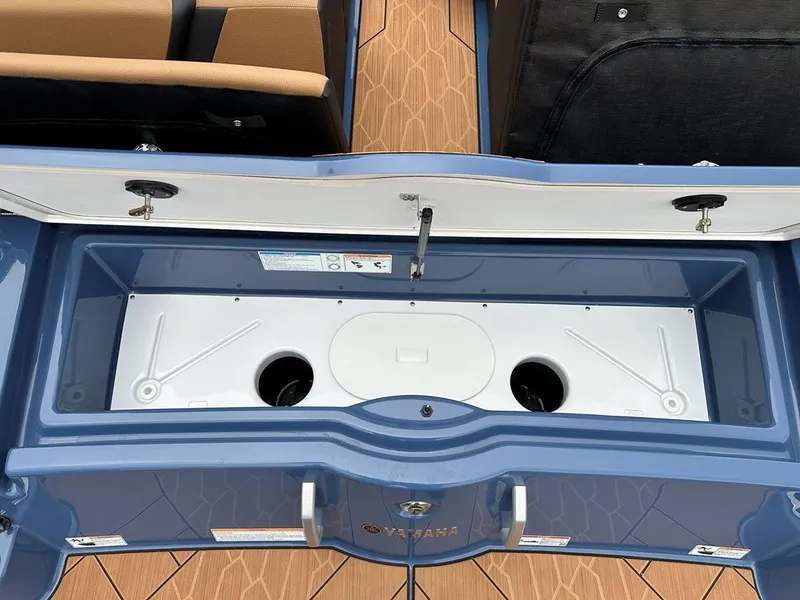 Slide: The Image of 2024 Yamaha 222XD jet boat storage compartment with open lid, showcasing interior design. - 24