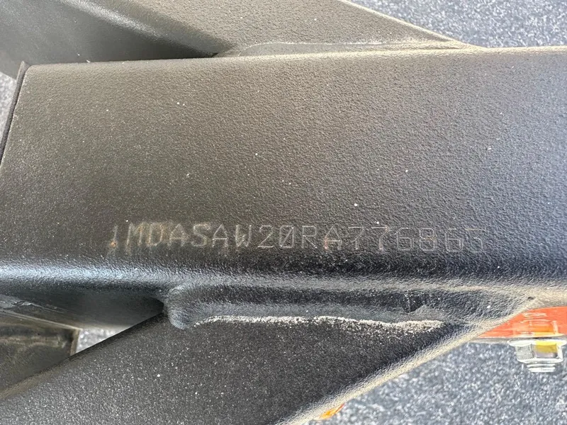 Slide: The Image of 2024 Yamaha AR220 jet boat hull identification number on black metal surface. - 23