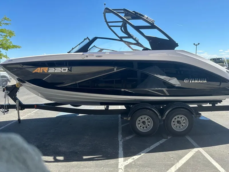 Slide: The Image of 2024 Yamaha AR220 jet boat on trailer, sleek design under clear blue sky. - 6
