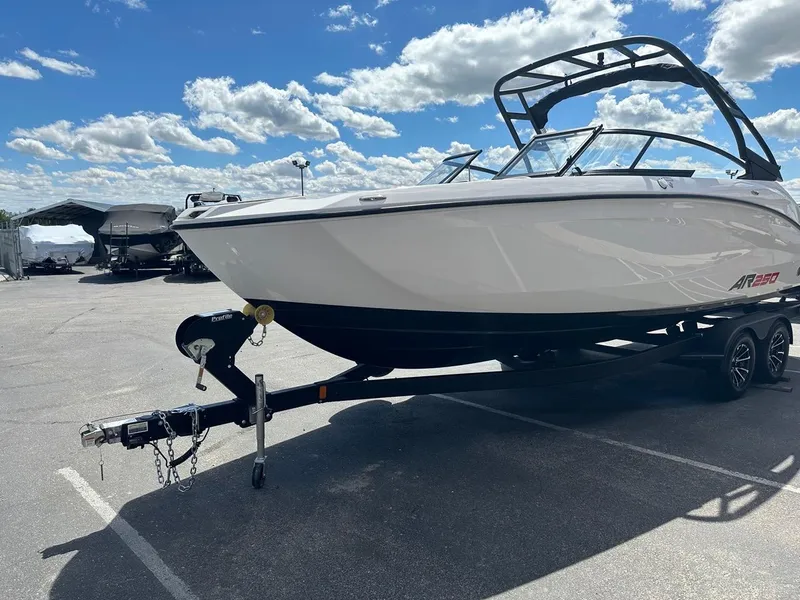 Slide: The Image of 2024 Yamaha AR250 jet boat on trailer under a blue sky. - 6