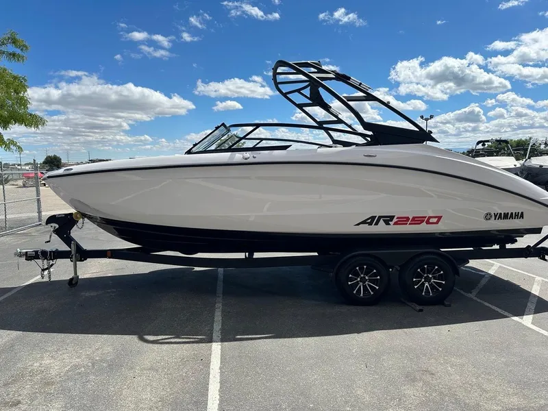 Slide: The Image of 2024 Yamaha AR250 jet boat on trailer under a clear blue sky. - 7
