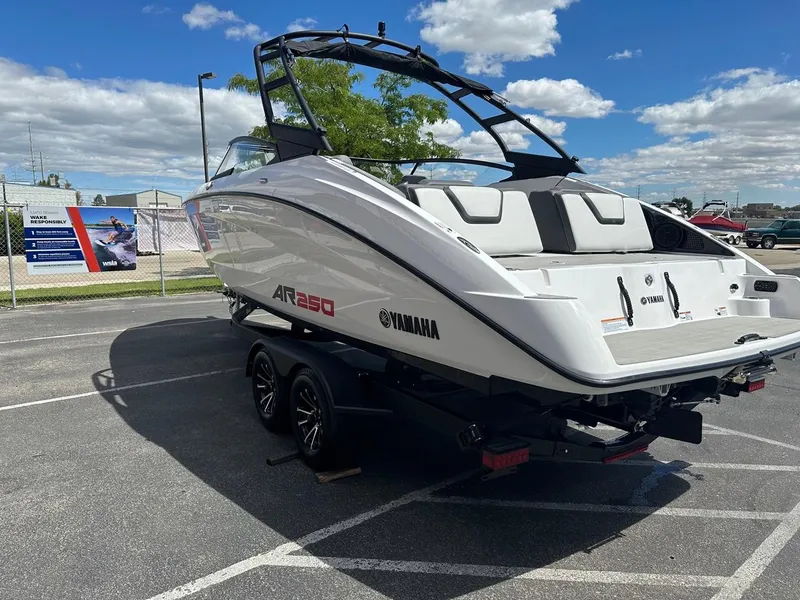 Slide: The Image of 2024 Yamaha AR250 jet boat on trailer under a clear blue sky. - 8