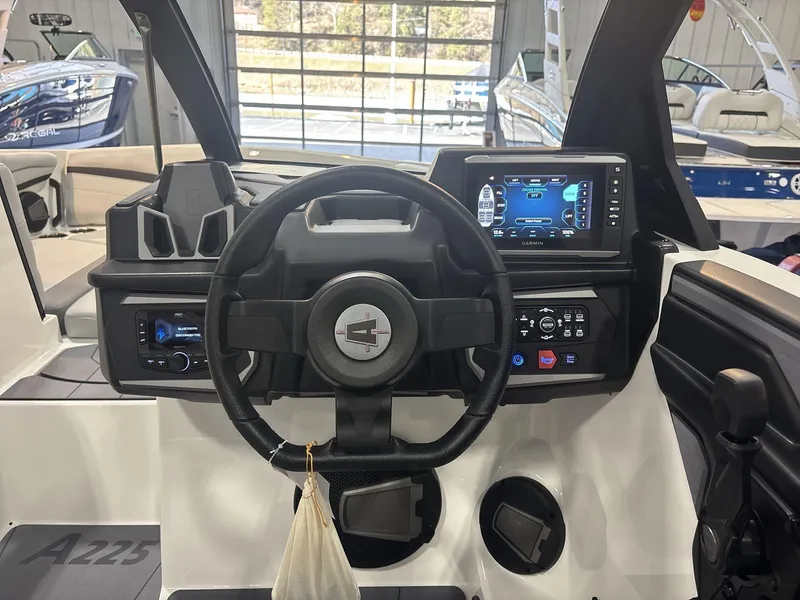 Slide: The Image of 2025 Axis A225 boat dashboard with steering wheel and digital display. - 11
