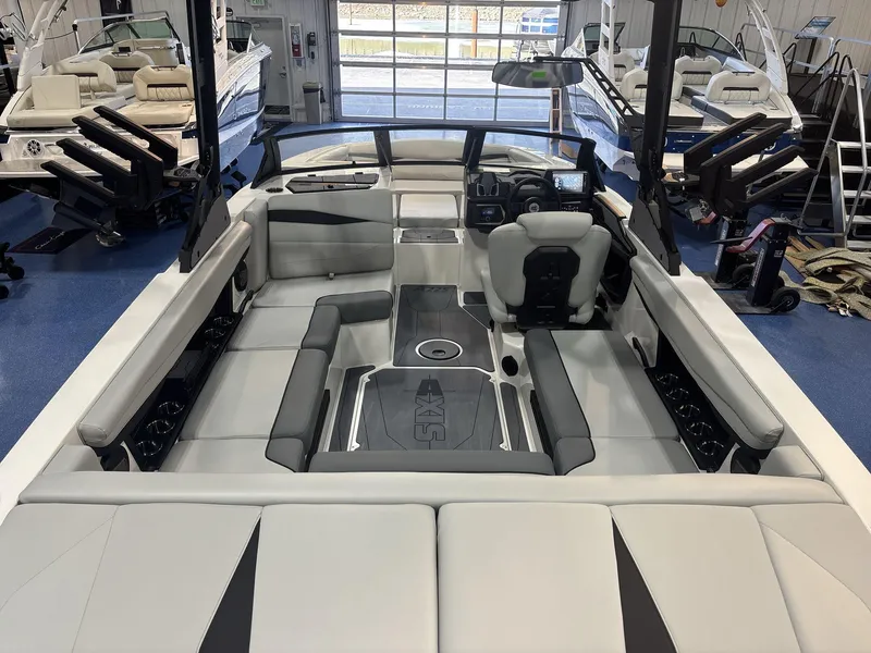 Slide: The Image of 2025 Axis A225 boat interior with modern seating and dashboard in showroom. - 6