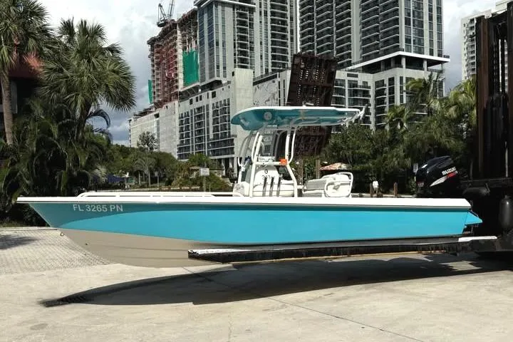 Slide: The Image of 2008 Everglades 243 CC boat in urban setting, turquoise hull, modern buildings background. - 0