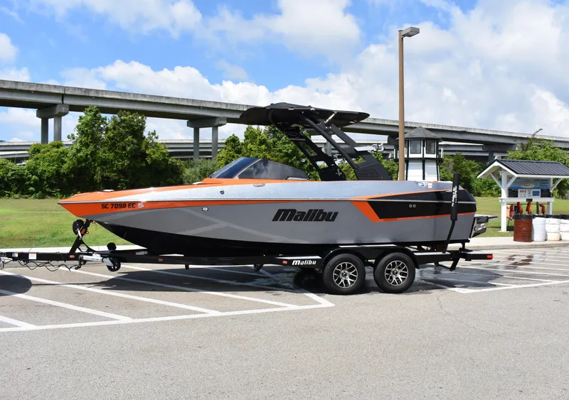 Slide: The Image of 2020 Malibu Wakesetter 22 MXZ boat on trailer in parking lot. - 1