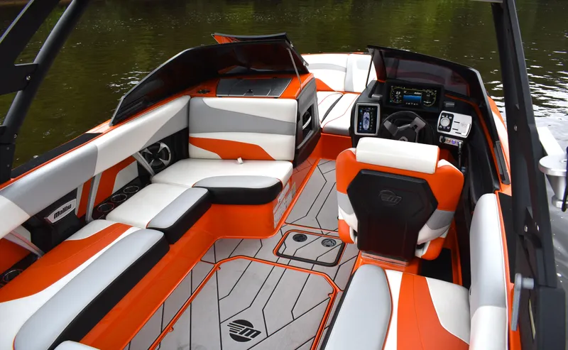Slide: The Image of 2020 Malibu Wakesetter 22 MXZ interior with orange and gray seating, modern dashboard. - 17