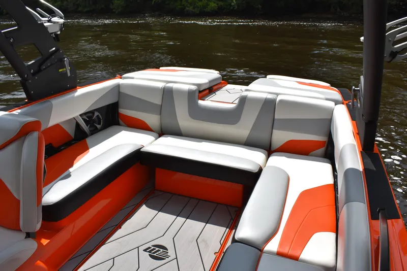 Slide: The Image of 2020 Malibu Wakesetter 22 MXZ interior with orange and white seating on a lake. - 23