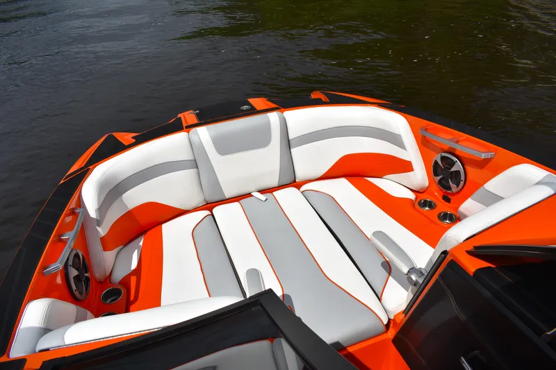 Slide: The Image of 2020 Malibu Wakesetter 22 MXZ boat interior with orange and white seating. - 24
