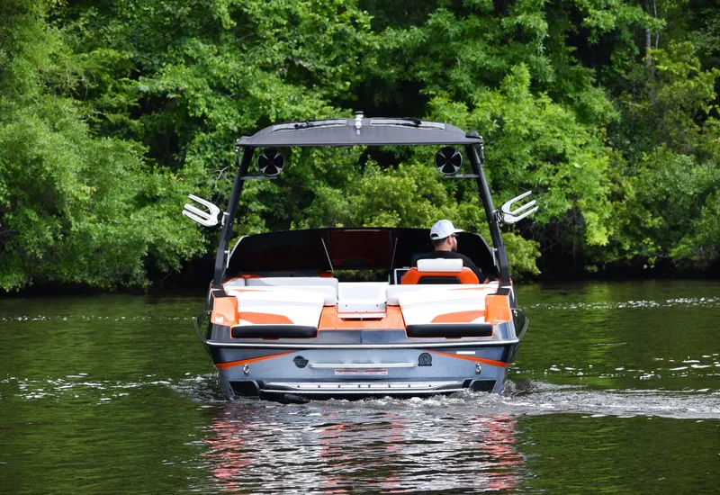 Slide: The Image of 2020 Malibu Wakesetter 22 MXZ on a serene lake, surrounded by lush greenery. - 6