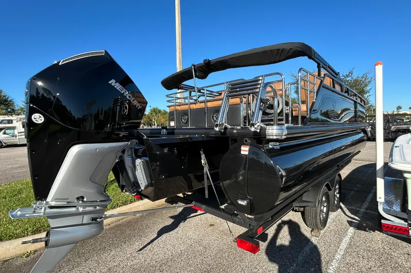 Slide: The Image of 2025 Regency 230 LE3 Sport pontoon boat with Mercury outboard motor, parked on a trailer. - 3