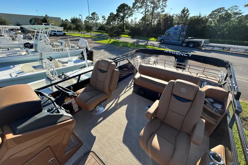 Slide: The Image of 2025 Regency 230 LE3 Sport boat interior with tan seating and steering console. - 5