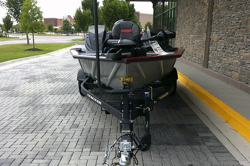 Slide: The Image of 2025 Tracker Pro Team 195 Tournament Edition boat on a trailer, parked on a paved driveway. - 2