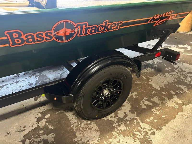 Slide: The Image of 2025 Tracker Bass Tracker Classic Limited boat trailer with black wheel. - 5