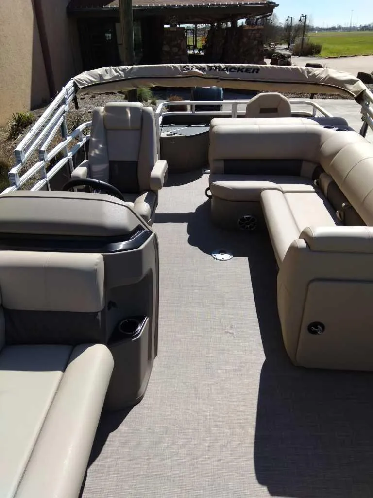 Slide: The Image of 2025 Sun Tracker SportFish 20 DLX pontoon boat interior with beige seating and spacious layout. - 4