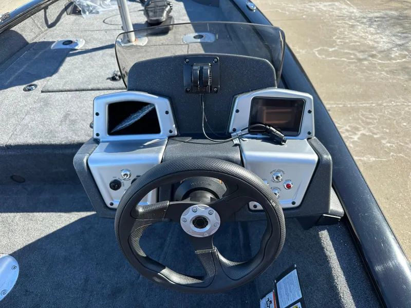 Slide: The Image of 2025 Tracker Pro Team 175 Crappie Edition boat dashboard with steering wheel and dual displays. - 5