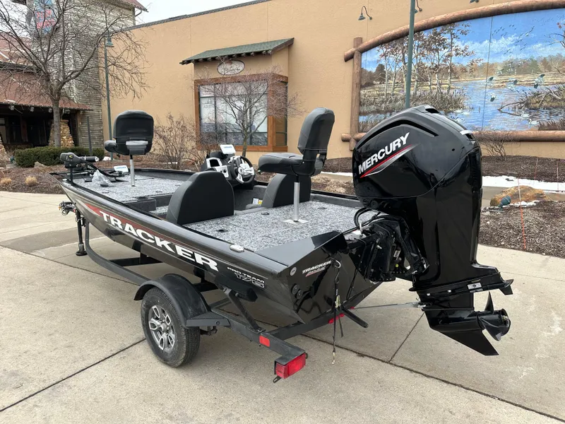 Slide: The Image of 2025 Tracker Pro Team 175 boat with Mercury engine, parked outdoors. - 2