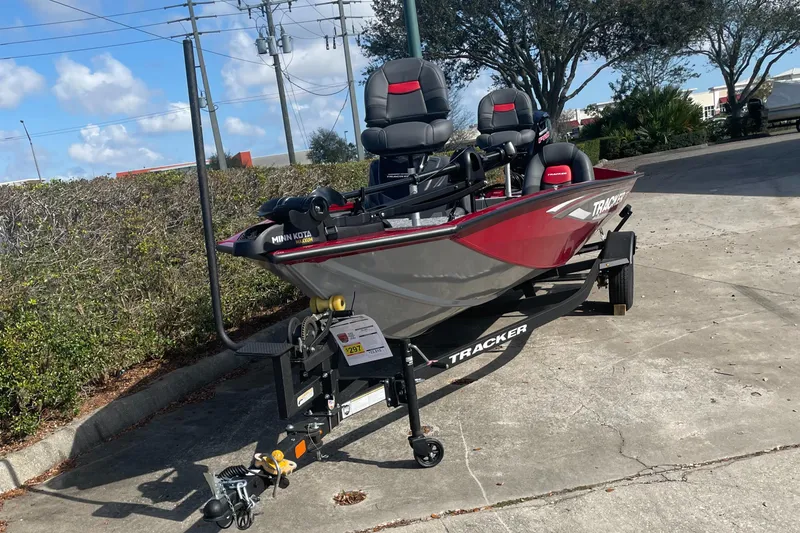 Slide: The Image of 2025 Tracker Pro Team 190 boat on trailer, parked outdoors under a clear sky. - 2