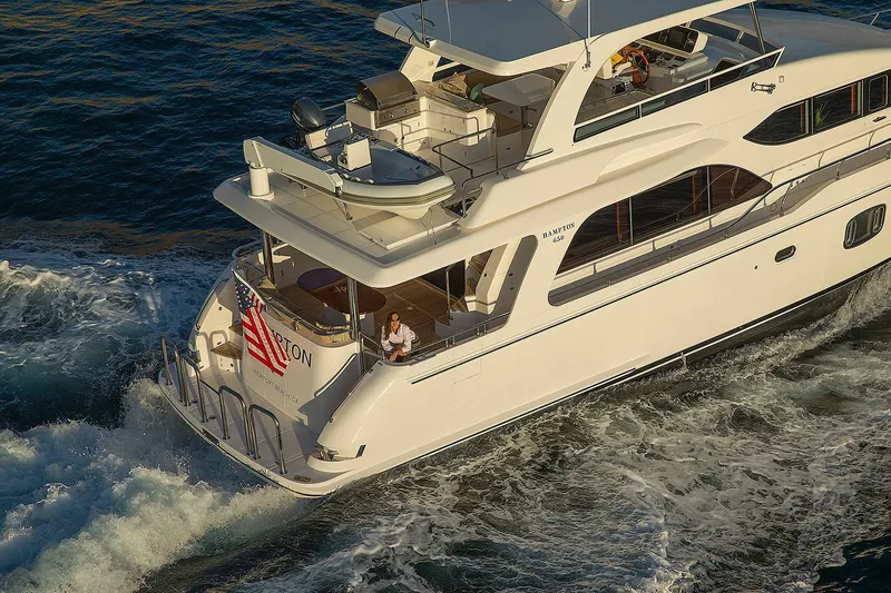 Slide: The Image of 2026 Hampton 650 Pilothouse yacht cruising on open water, featuring elegant design and spacious deck. - 27