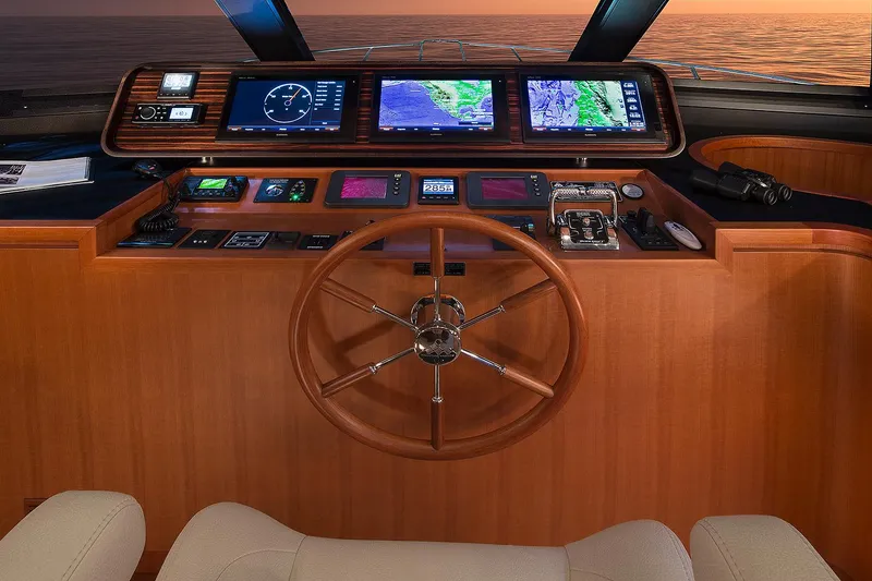 Slide: The Image of 2026 Hampton 650 Pilothouse helm with advanced navigation displays and wooden steering wheel. - 9