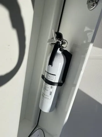 Slide: The Image of 2022 Everglades 235CC boat interior, featuring a cushioned seat and storage compartment. - 26