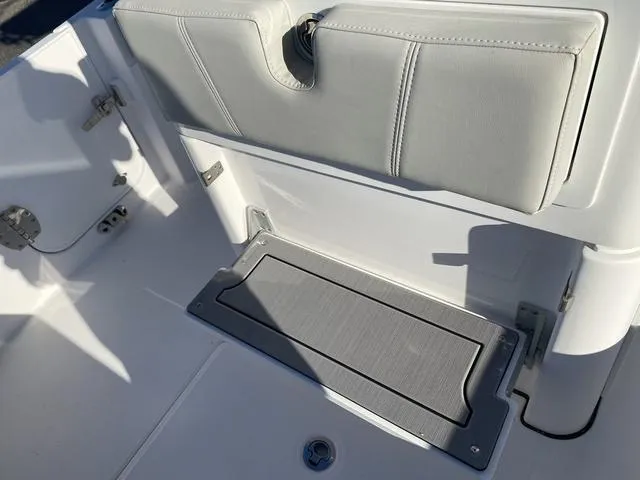 Slide: The Image of 2022 Everglades 235CC boat interior, featuring sleek white seating and storage compartment. - 38
