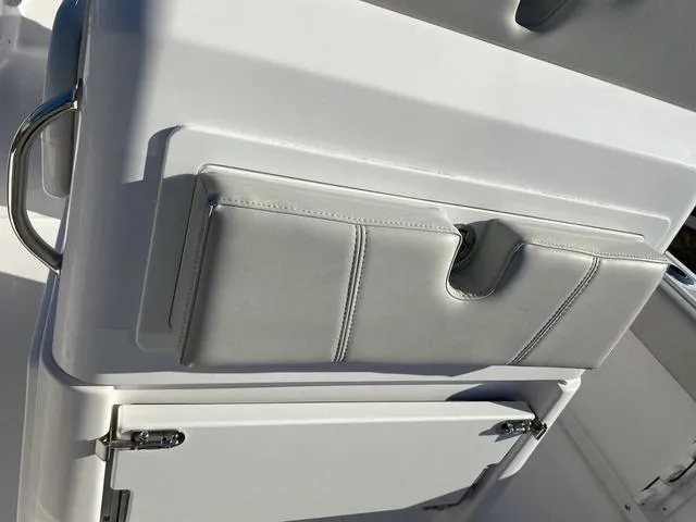 Slide: The Image of 2022 Everglades 235CC boat storage compartment, open and empty, with white interior. - 46