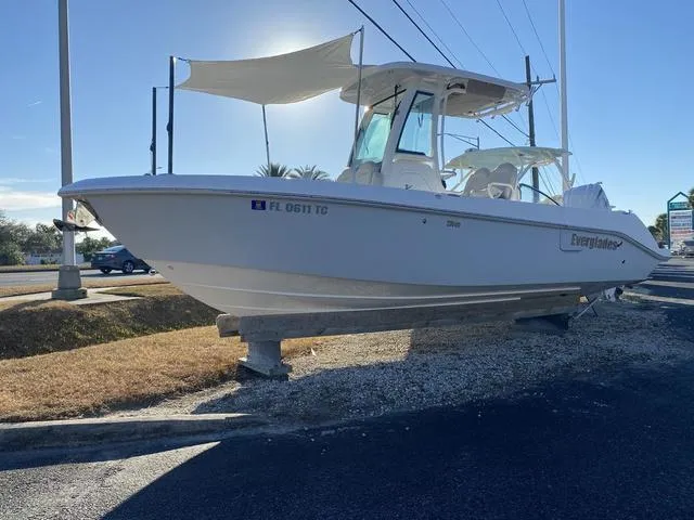 Slide: The Image of 2022 Everglades 235CC boat with outboard motor, parked outdoors on a sunny day. - 7