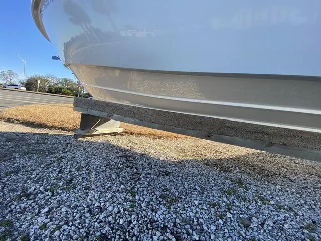 Slide: The Image of 2022 Everglades 235CC boat with T-top and speakers under clear blue sky. - 8