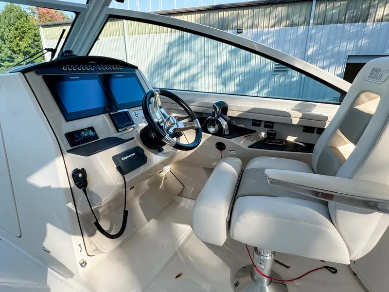 Slide: The Image of 2017 Boston Whaler 320 Vantage helm with dual screens and comfortable seating. - 13