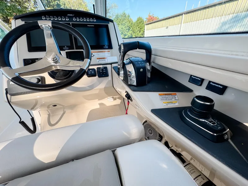 Slide: The Image of 2017 Boston Whaler 320 Vantage helm with steering wheel and control panel. - 14