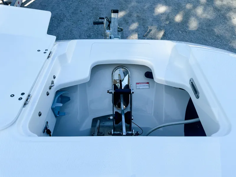 Slide: The Image of 2017 Boston Whaler 320 Vantage anchor compartment, open and empty, on a sunny day. - 17