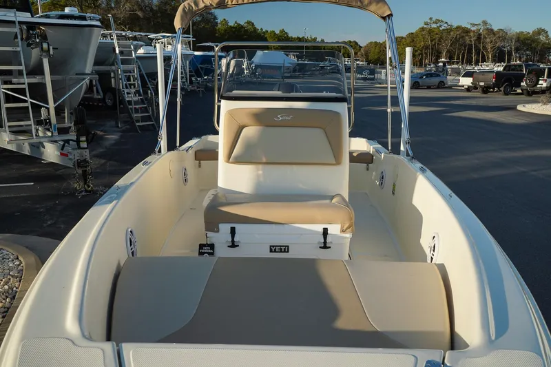 Slide: The Image of 2025 Scout 175 Sportfish boat with beige seating and Yeti cooler on deck. - 10