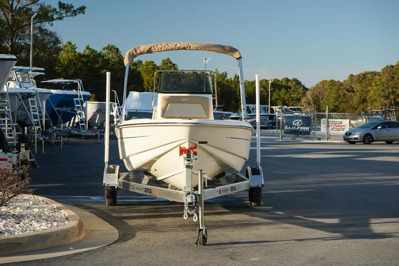 Slide: The Image of 2025 Scout 175 Sportfish boat on trailer in marina parking lot. - 2