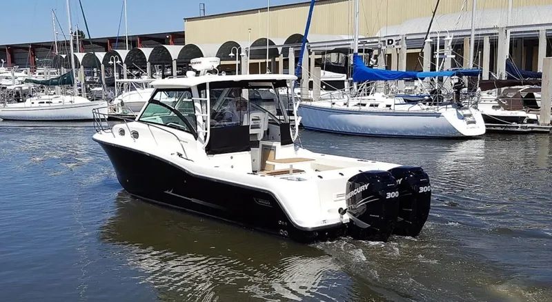 Slide: The Image of 2014 Boston Whaler 315 Conquest boat in marina, featuring dual Mercury engines. - 0