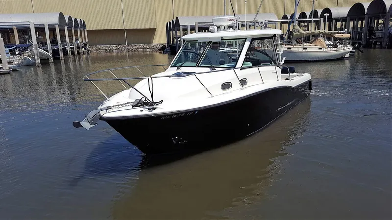 Slide: The Image of 2014 Boston Whaler 315 Conquest boat docked in a marina. - 1