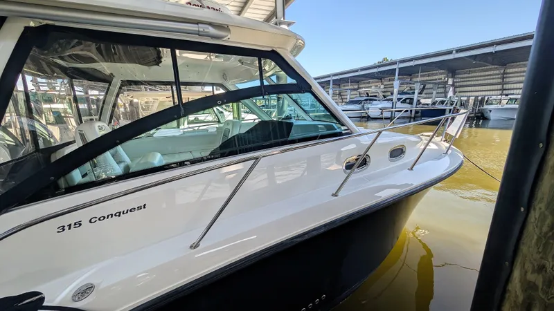 Slide: The Image of 2014 Boston Whaler 315 Conquest boat docked in a marina, side view. - 11